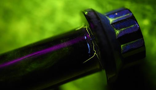 Cracks on this main landing wheel bolt are made visible under black light. Photo by Airman 1st Class Kevin Sommer Giron.