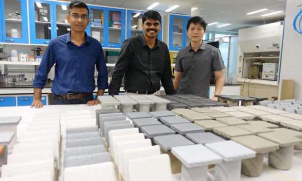 NTU scientists stand behind rows of coated steel plates used in their research and development efforts. Photo courtesy of NTU Singapore.