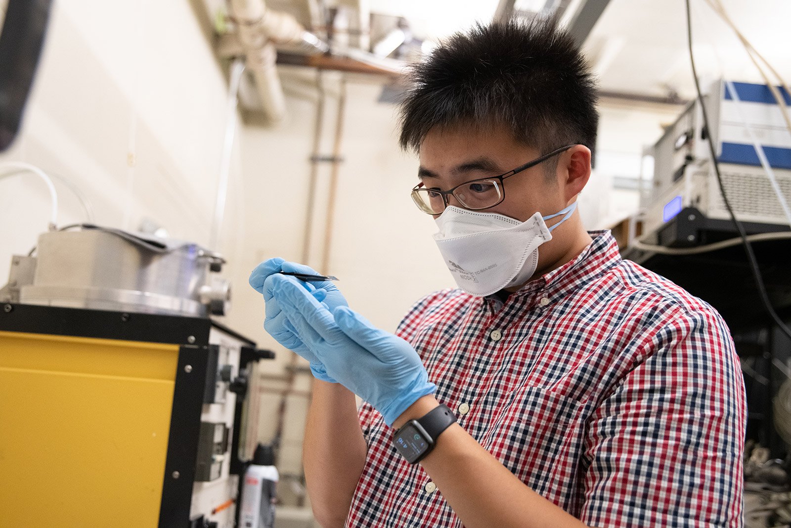 Chen-Hsuan (Steve) Lu inspects a substrate coated in graphene. Photo courtesy of Caltech.