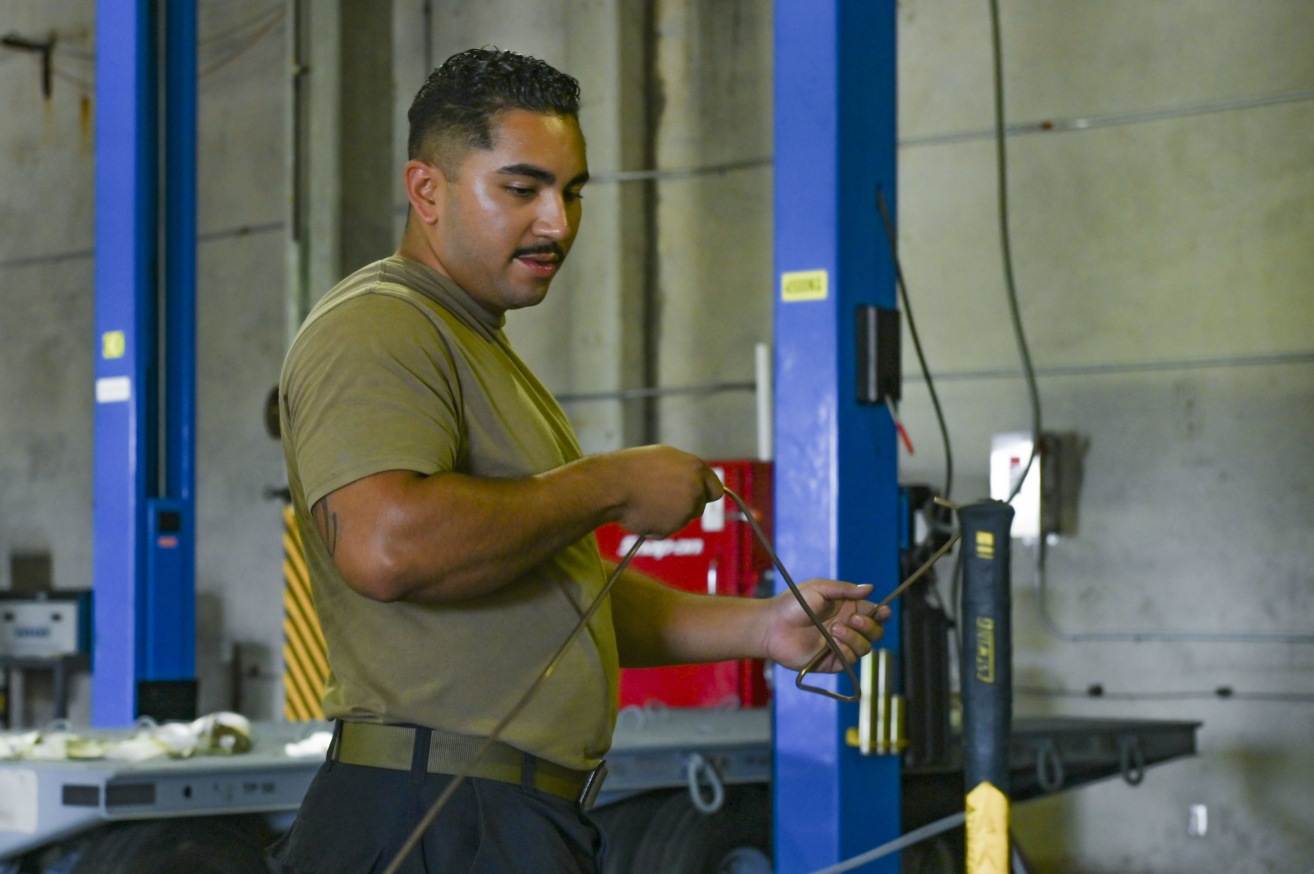 Senior Airman Jonathan Enriquez prepares to install a copper-nickel alloy brake line on a munitions trailer. U.S. Air Force photo by Breanna Christopher Volkmar.