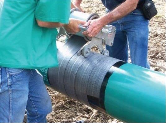 FIGURE 3 Field application of (non-shielding) mesh-backed tape on girth weld of FBE coated pipe.